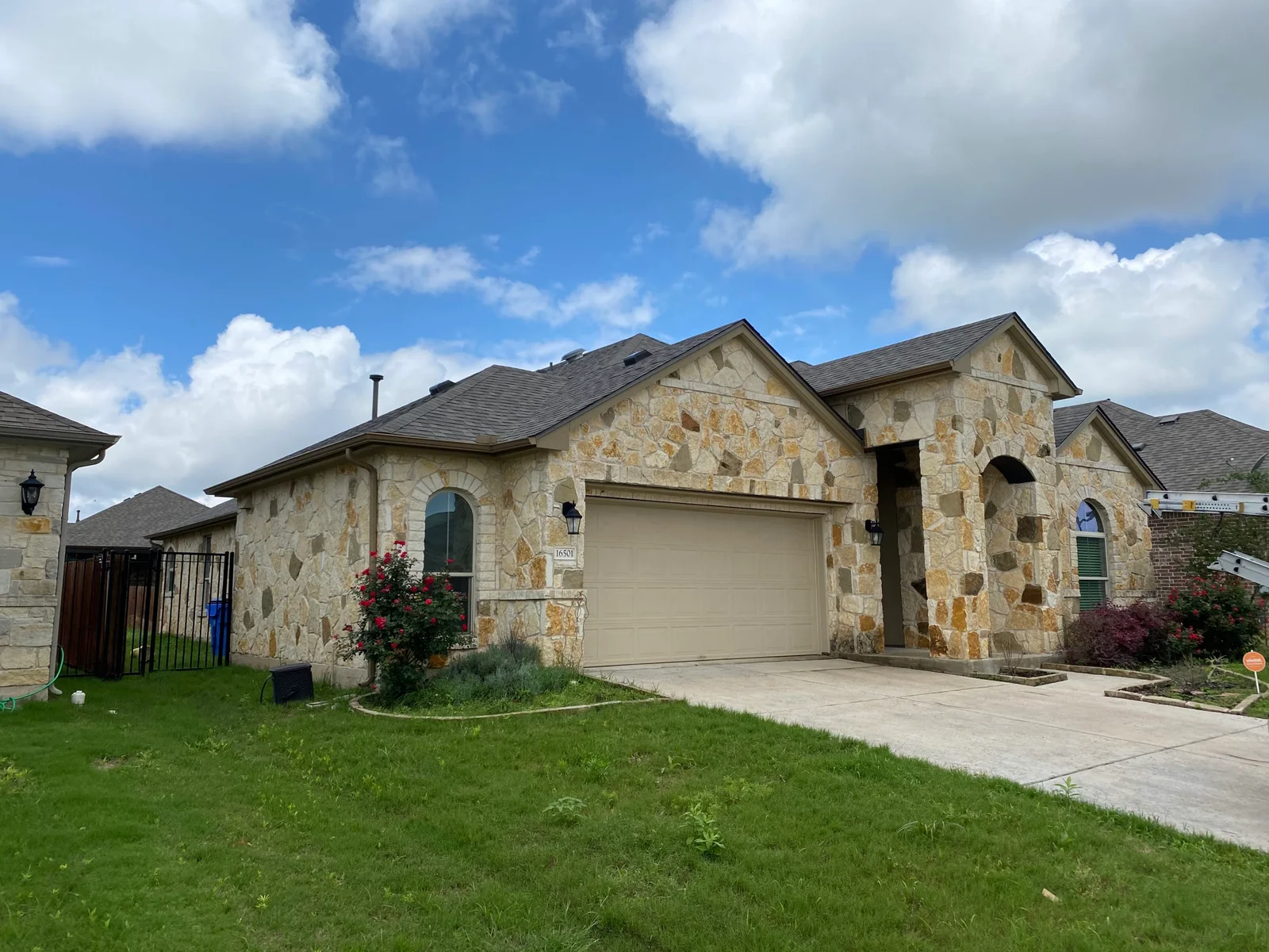 An actual Acura Roofing portfolio photograph of a shingle roof on a limestone home